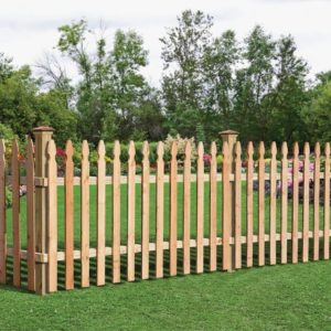 A French Gothic incense cedar picket fence on a bright green lawn