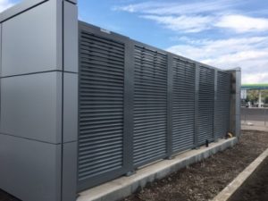 Gunmetal gray horizontal louvered panels securing an outdoor mechanical equipment system