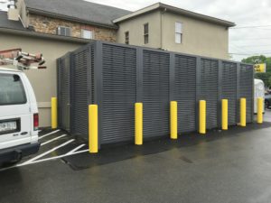 Dark grey PalmSHIELD horizontal louvers installed behind yellow traffic posts in front of Mission Dispensary in Allentown, PA