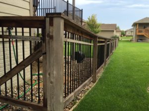Custom wood fencing with American Fence Company plaque stretching across a large, vibrant green lawn