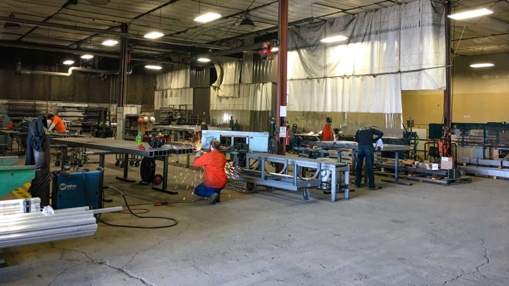 Custom metals shop with workers creating fence materials.