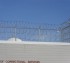 The rooftop view of a high security fence with four stack Concertina wire