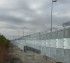 Two parallel stretches of ballistic high security fencing. The front section is shorter and has barb wire on time, where as the second stretch is about 1/3 taller and has razorwire and barb wire.