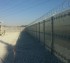 Ballistic high security fencing with no visibility and coils of razor wire on top for extra security
