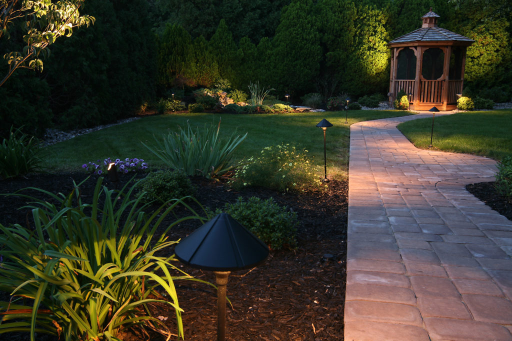 landscaped backyard with brick walkway and custom gazebo