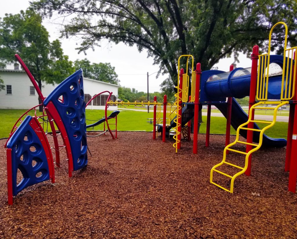 Vibrant play ground with climbing features, slides, steps and fireman's pole