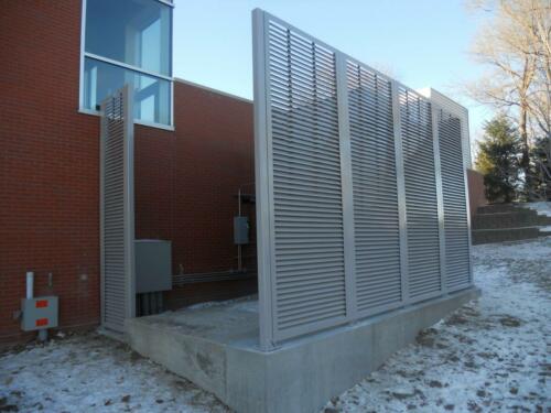 6-8 foot grey louvers on cement creating a partial enclosure