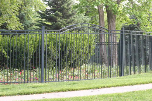 6-8 foot tall ornamental black iron fence with gradually inclined overscalloped gate