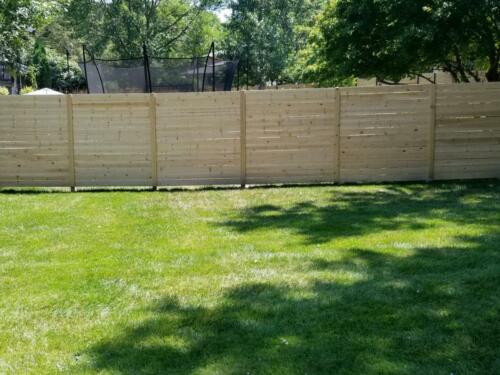 6-8 foot tall horizontal wooden fence with wooden vertical fence posts