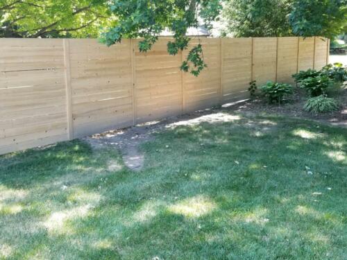 6-8 foot tall semi-private horizontal wooden fence with wooden vertical fence posts