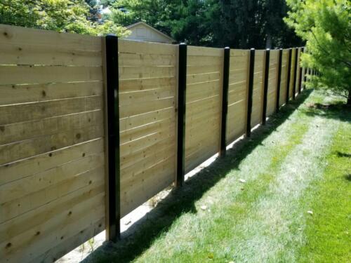 6-8 foot tall horizontal wooden fence with black metal fence posts