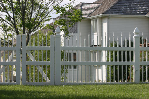 5-7 foot tall white ornamental iron fence with small pointed spires of alternating heights on top of each rod