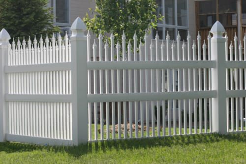 5-7 foot tall white ornamental iron fence with small pointed spires of varying heights on top of each rod