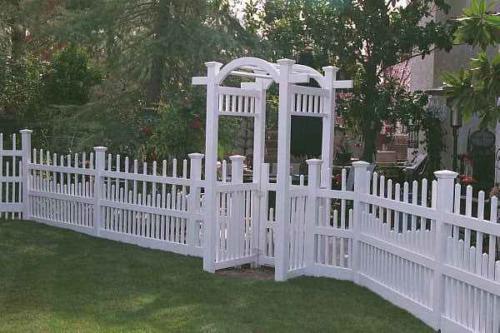 3-5 foot tall underscalloped white fence with a narrow decorative 5-7 foot white gateway