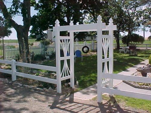2-4 foot tall white fence railings with a 6-8 foot white boxed archway with no gate