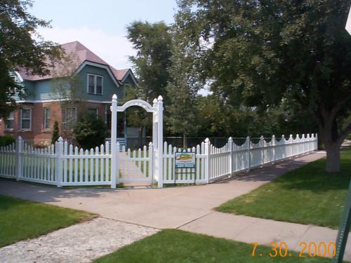 3-5 foot tall underscalloped white fence with a narrow decorative 5-7 foot white gateway