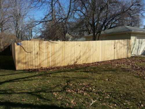 5-7 foot tall wooden privacy fence enclosing a yard