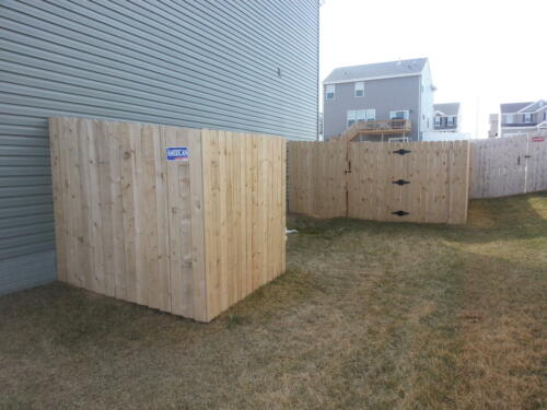 5-7 foot tall wooden privacy fence enclosing a yard with two to three similarly styled single swing gate
