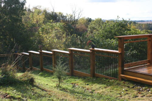 2-4 foot wooden railing that staggers to accommodate uneven grass terrain