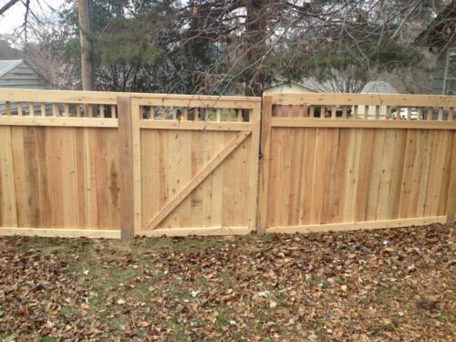4-6 foot tall privacy picket fence with custom 2-5 inch vertical gaps that run horizontally across the top with a similar single swing gate