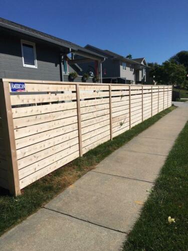 6-8 foot tall horizontal wooden fence with off-colored post
