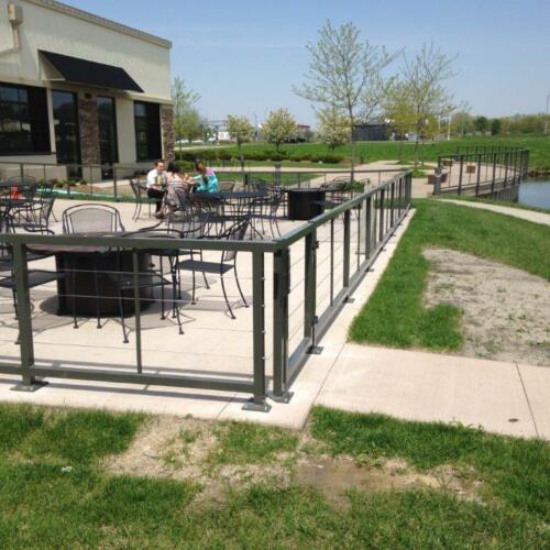 3 - 4 foot tall black metal handrails enclosing outdoor dining area