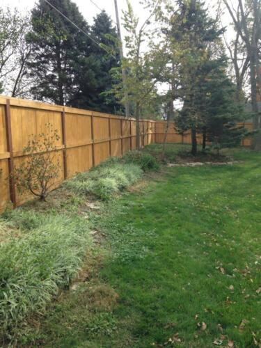 6-8 foot tall wooden privacy fence with horizontal reinforcement plank centered post to post
