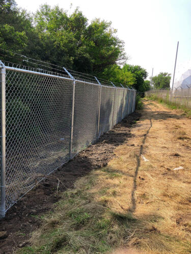 6-8 foot grey high security chain link fence with 3 - 5 lines of barb wire at the top