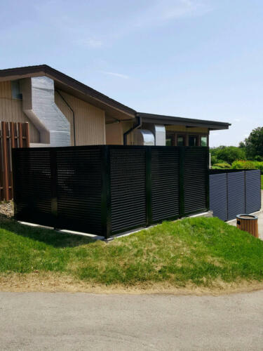 6-8 foot black louvers on cement creating an enclosure