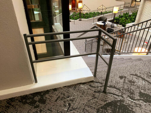 3 - 4 foot tall gray metal handrails for short ramp - close up of edge of rail