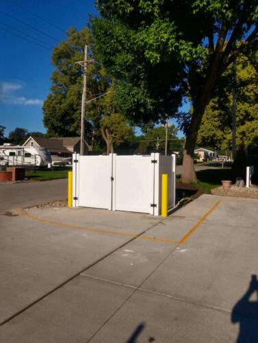 4-6 foot tall white vinyl fence with manual swing gates creating small enclosure