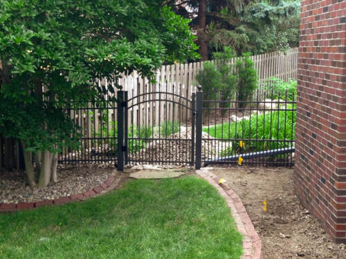 4 - 6 foot tall black custom ornamental fence with arched swing gate