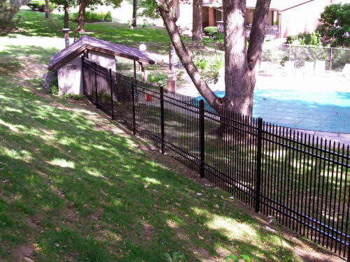 4 - 6 foot tall black ornamental fence enclosing a swimming pool
