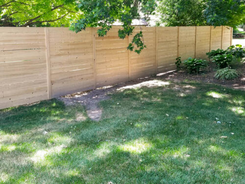 6-8 foot tall flat horizontal wooden semi-private fence with small same color vertical fence posts