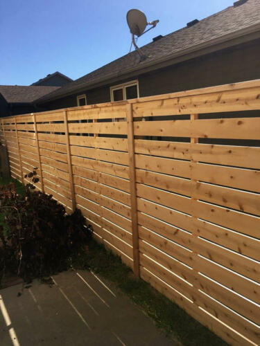 6-8 foot tall semi-private wooden fence with same color vertical fence posts alternating sides of the fence