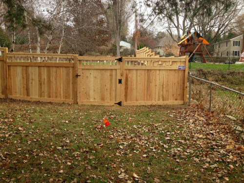 4-6 foot tall privacy picket fence with custom 2-5 inch vertical gaps that run horizontally across the top with a similar single swing gate
