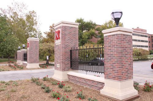 3-5 foot tall decorative black ornamental fence connecting two brick columns