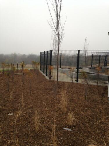 6 - 8 foot black woven and welded wire fence creating an enclosure (corner view)