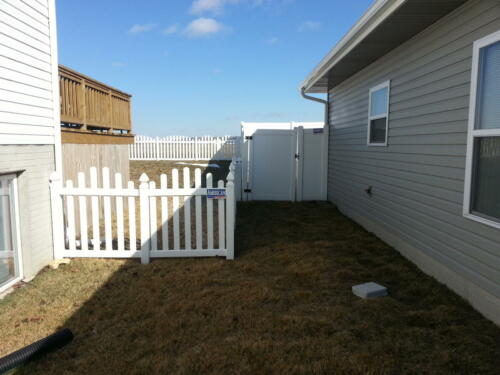 4-6 foot white vinyl picketed fence with an over-scalloped cut